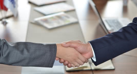 A hand gives a business card to an another hand